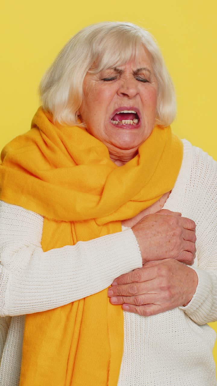 Stressed sick senior woman suffers from tension holding chest with heart pain attack risk of stroke
