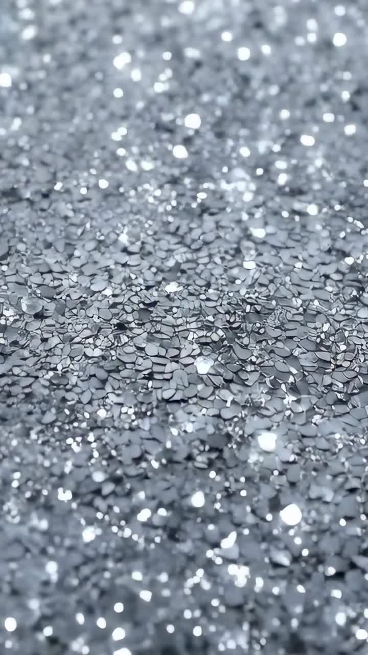 Video verticale: cambio della messa a fuoco della camera che rivela paillettes argentate sul tavolo per mostrare la brillantezza