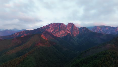 Vista-Panorámica-De-La-Montaña,-El-Sol-Poniente-Tiñe-De-Rojo-Las-Cimas-De-Las-Montañas
