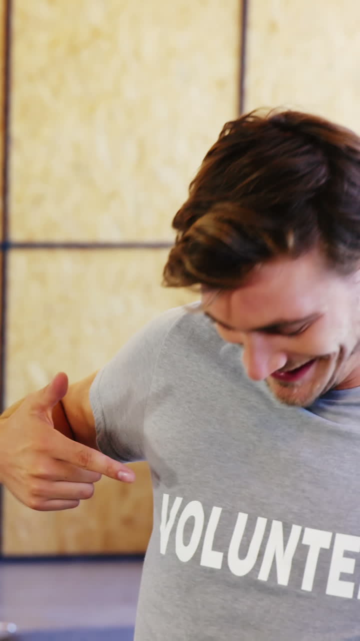 улыбающиеся добровольцы указывают на футболку.