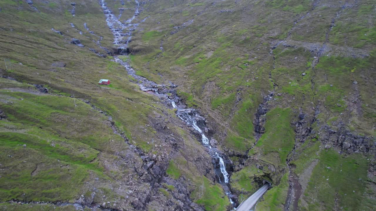 los coches entran en un túnel junto a cascadas y arroyos cerca de arnafjordur, islas feroe