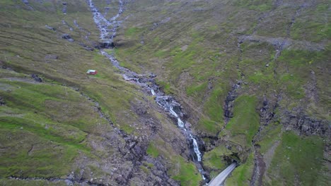 los coches entran en un túnel junto a cascadas y arroyos cerca de arnafjordur, islas feroe