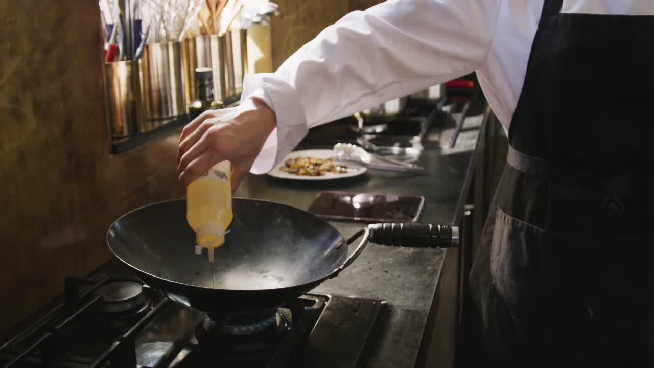 Chef che aggiunge olio nella padella