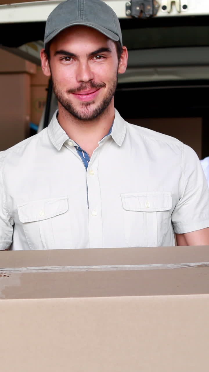 el conductor de la entrega y el equipo de negocios sonriendo a la cámara