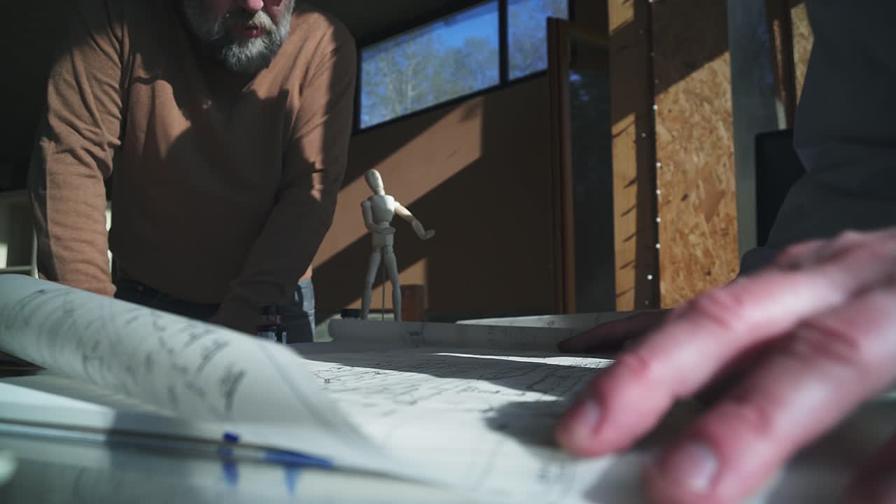 dos diseñadores arquitectos discuten los detalles sobre los planes de diseño