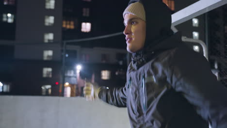 portero en movimiento durante una sesión de entrenamiento nocturno, preparándose para atrapar una pelota, con edificios residenciales en el fondo, destacando su enfoque y agilidad