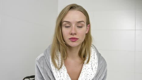 serious woman in bathroom looking to camera