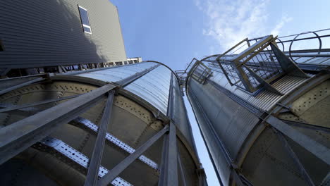 metal storage tanks. large grain elevators against blue sky. modern warehouse. close-up. view from below.