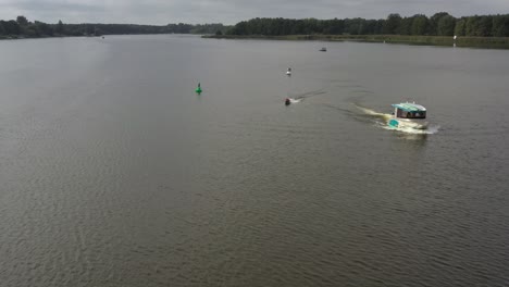 Tiro-De-Drone-De-Surfergirl-En-Longboard-Detrás-Del-Barco