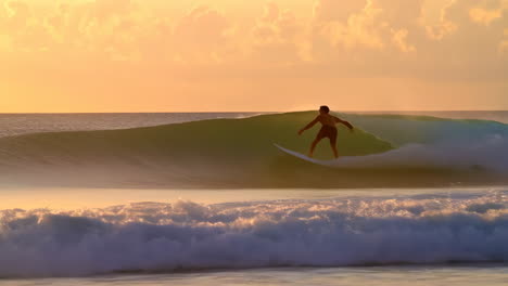 surfer riding a wave at sunset