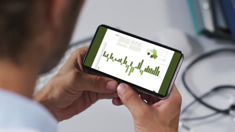 manos de un hombre caucásico usando un teléfono inteligente con estadísticas en la pantalla