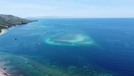 aerial view rising over stunning seascape of coral triangle reef marine ecosystem on remote tropical atauro island in east timor, southeast asia with expansive crystal clear blue ocean