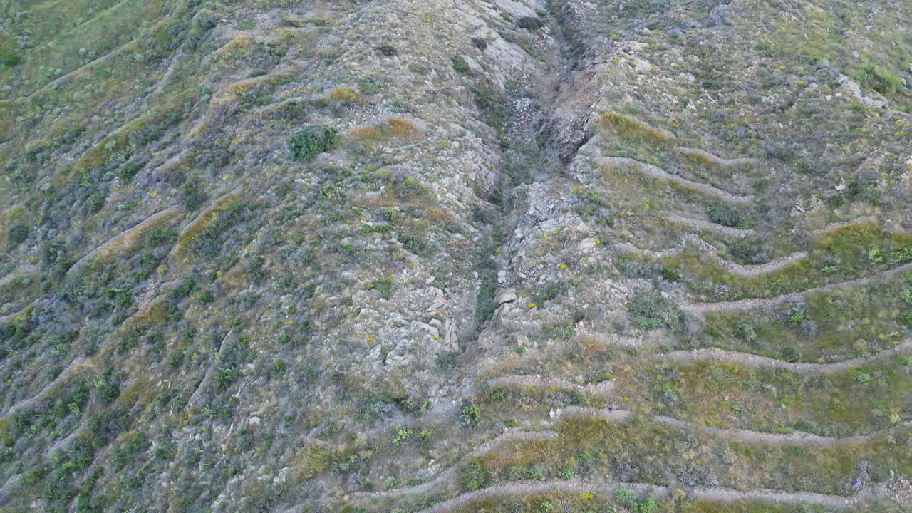 Aerial: Slow vertical drone shot showing cliffs, a road and open sea in Spain