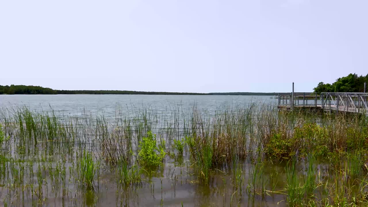 Static video of Lake Murray in Oklahoma. Grass is seen in front and a dock to the right
