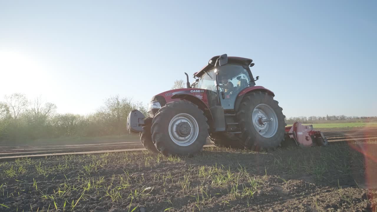 A tractor with blades cuts holes to prepare the field before fertilizing and seeding. Agricultural machinery.