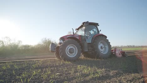 a tractor with blades cuts holes to prepare the field before fertilizing and seeding. agricultural machinery.