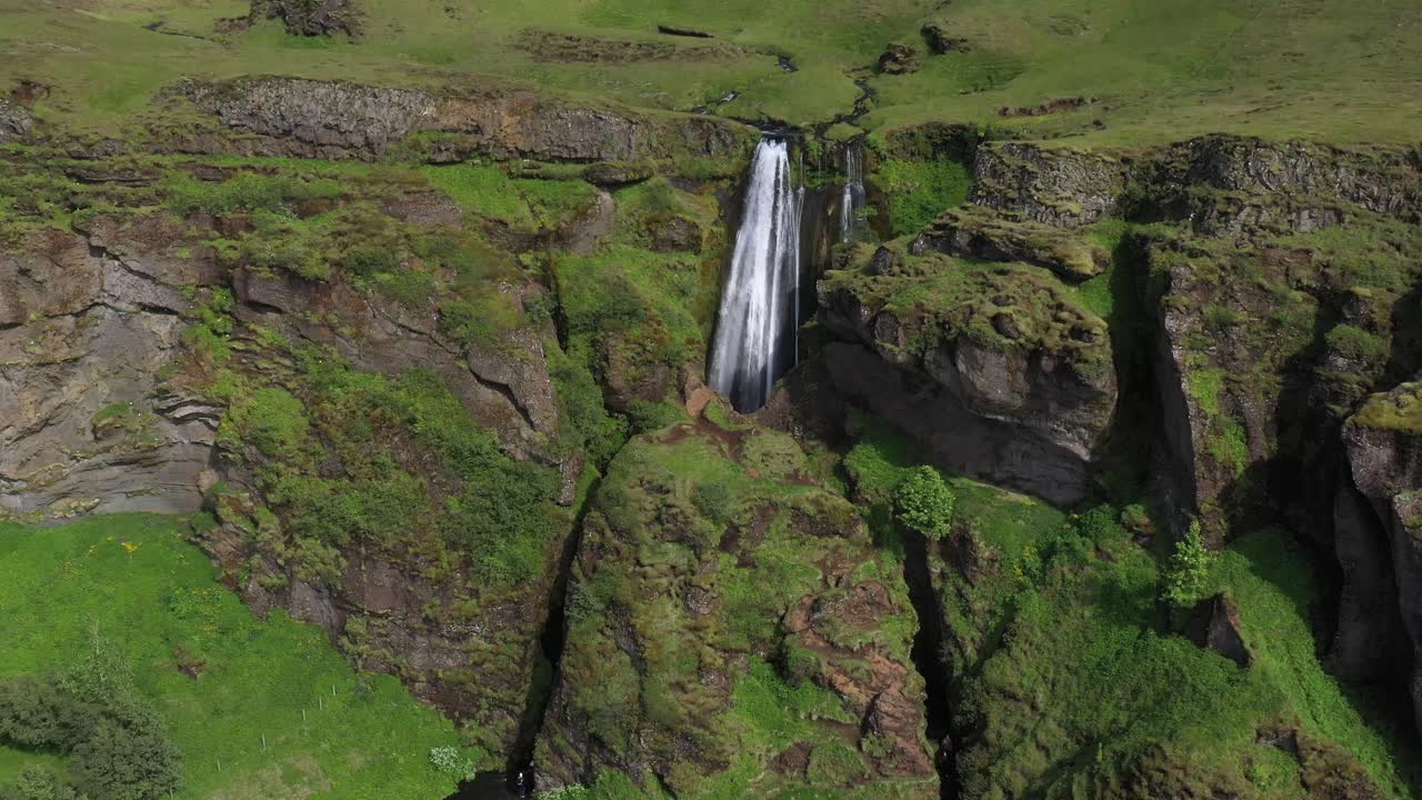 pequeña cascada en islandia con un video de un dron sacando una toma amplia