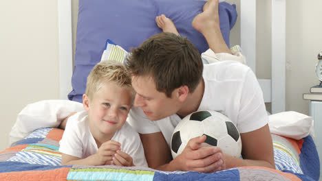 Padre-E-Hijo-Viendo-Un-Partido-De-Fútbol-En-El-Dormitorio