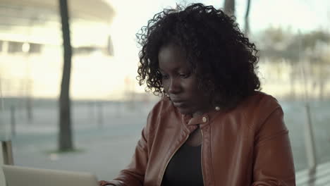 Overworked-African-American-woman-using-laptop-in-cafe