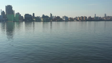 A-low-angle-drone-shot-over-a-calm-Hudson-River-at-sunrise