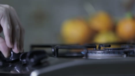 close up of a man´s hand lighting up a stove burner