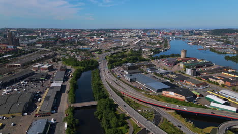 aerial view of modern freeway in gothenburg, sweden with small bridge over gota river on a sunny day - drone shot