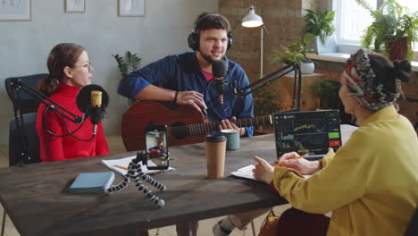 músico masculino dando una entrevista de podcast a las anfitrionas