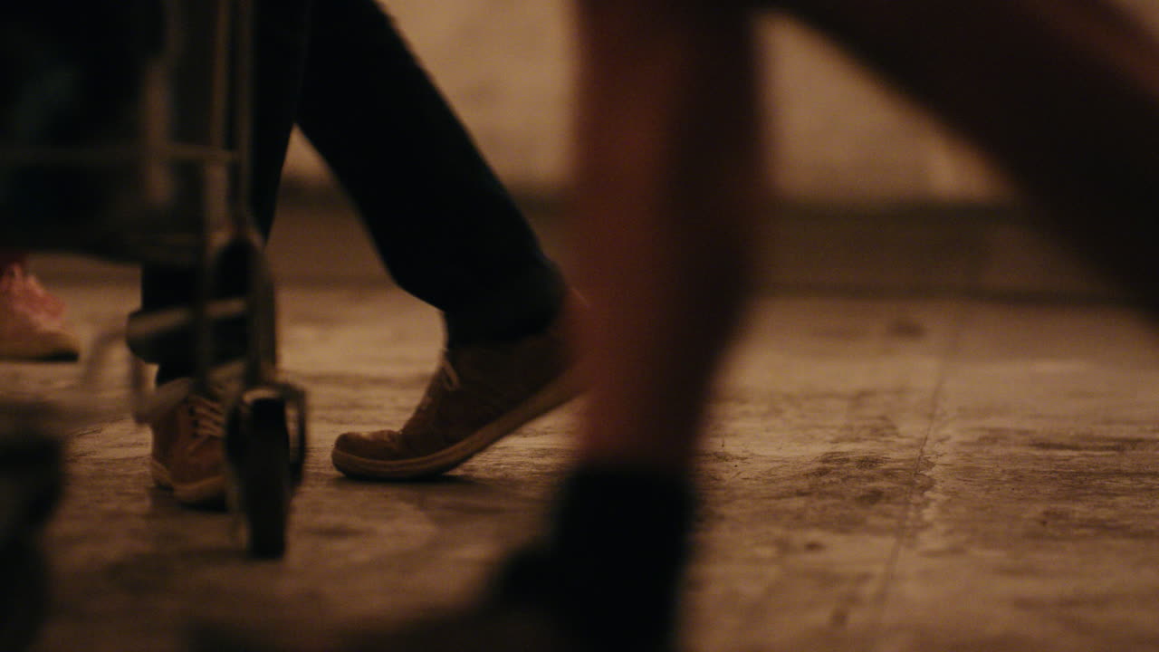 grupo cercano de amigos jugando con el carrito de compras divirtiéndose en la azotea por la noche disfrutando de la fiesta de celebración de fin de semana