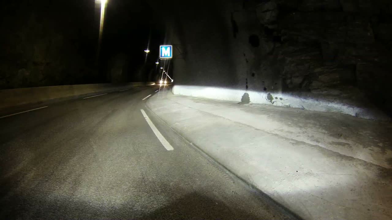 Visão em primeira pessoa de um carro a viajar por um túnel de pista única através de uma montanha