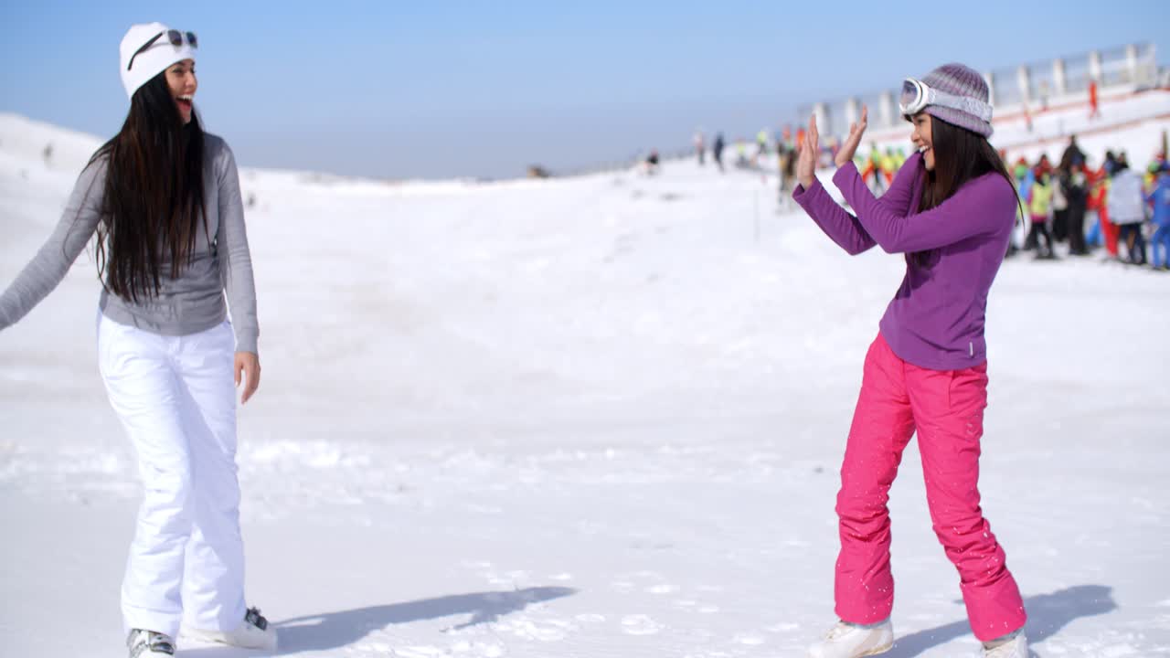 dos mujeres jóvenes teniendo una pelea de nieve