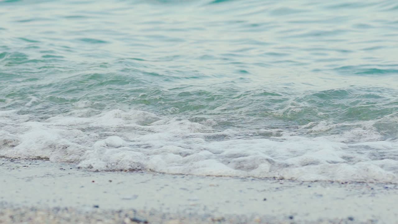 Female strolling on sand near sea. Legs of young woman close-up. Slow motion.