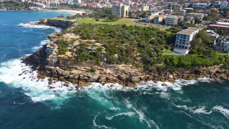 Olas-Rompiendo-En-El-Acantilado-Rocoso-De-La-Península-Con-Hoteles-Frente-Al-Mar---Bahía-Gordons-En-Coogee,-Nsw,-Australia