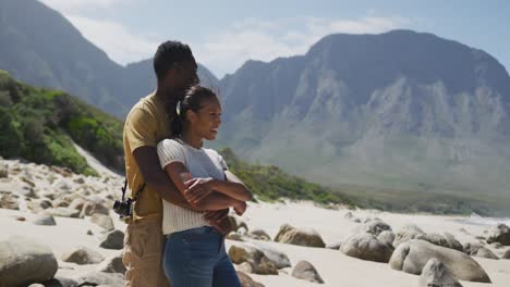 pareja afroamericana abrazándose mientras caminan en las montañas