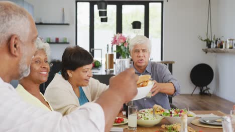 happy senior diverse people having dinner at retirement home