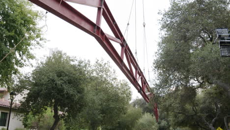 large red metal truss structure suspended outdoors