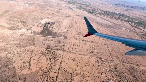 una foto del desierto de sonora a través de la ventana de un avión.