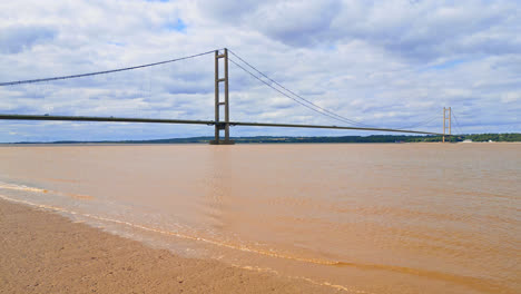 A-drone-video-shows-Humber-Bridge,-12th-largest-suspension-span,-crossing-River-Humber,-linking-Lincolnshire-to-Humberside-amid-traffic