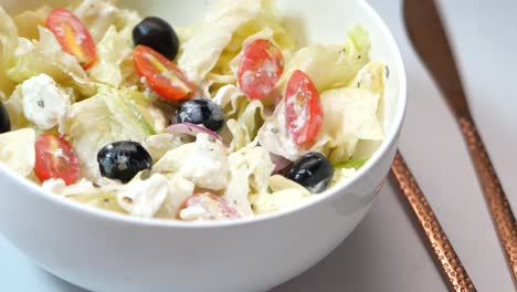 delicious greek salad in a white bowl