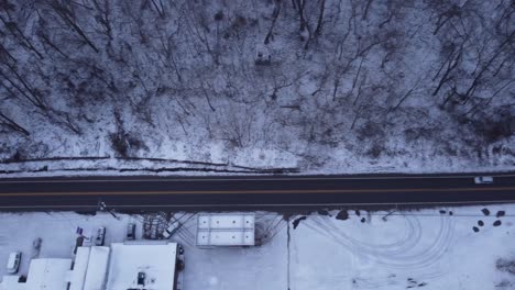 Drone-Volando-Sobre-Una-Carretera-Mientras-Pasa-Un-Automóvil