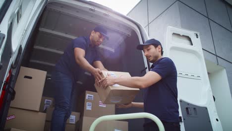 bottom view of couriers unloading packages from a delivery truck