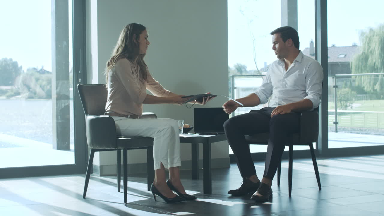 Business man signing document. Business people sitting in big house.