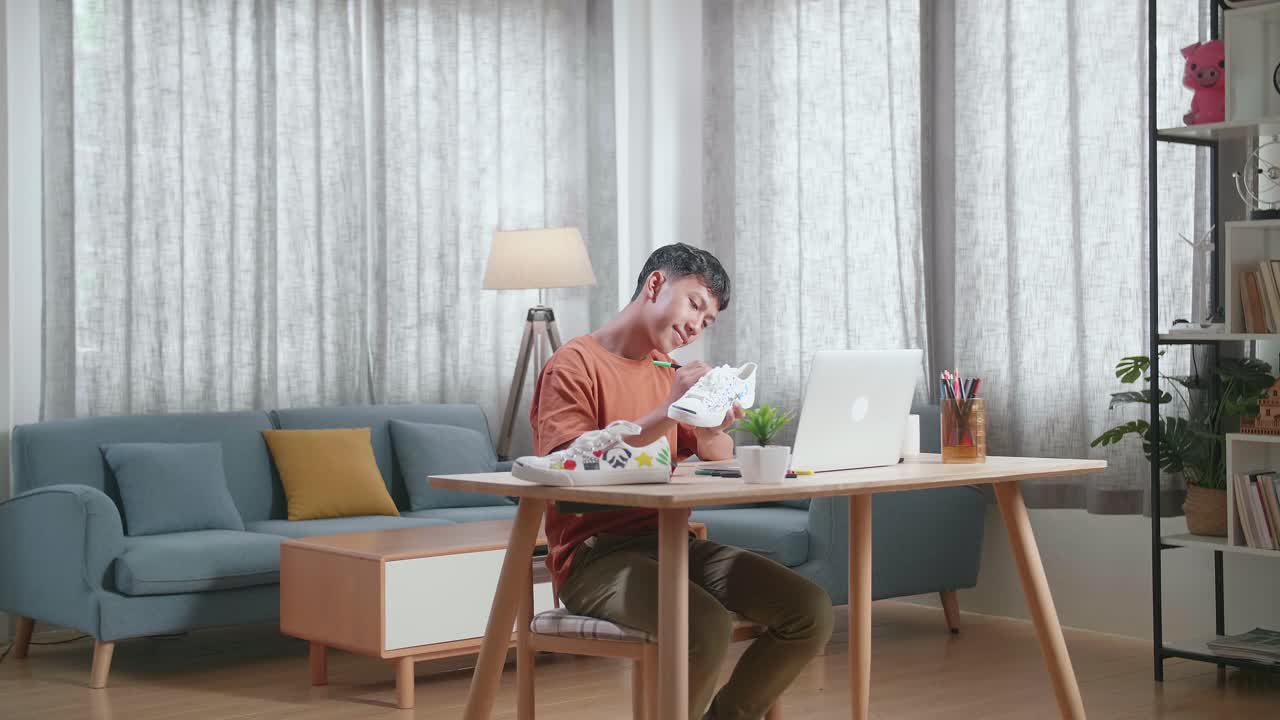 젊은이가 집에서 신발을 칠하고 있습니다.