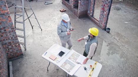 construction site with engineers reviewing plans