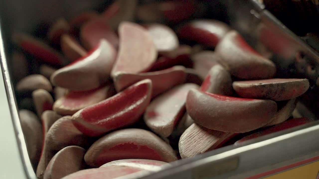 Close-up of a Box Filled with Many Small, Red Wooden Pieces