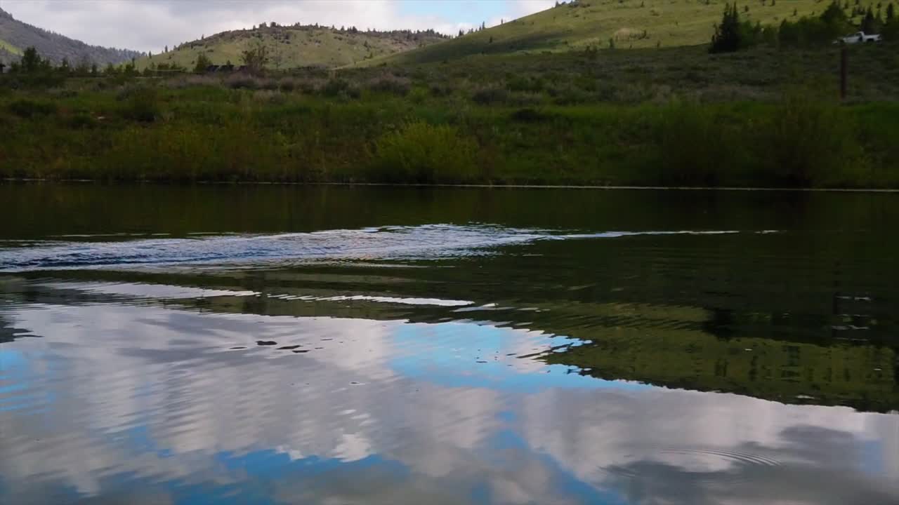 se ve un gancho de pesca saltando a través de la parte superior de un estanque