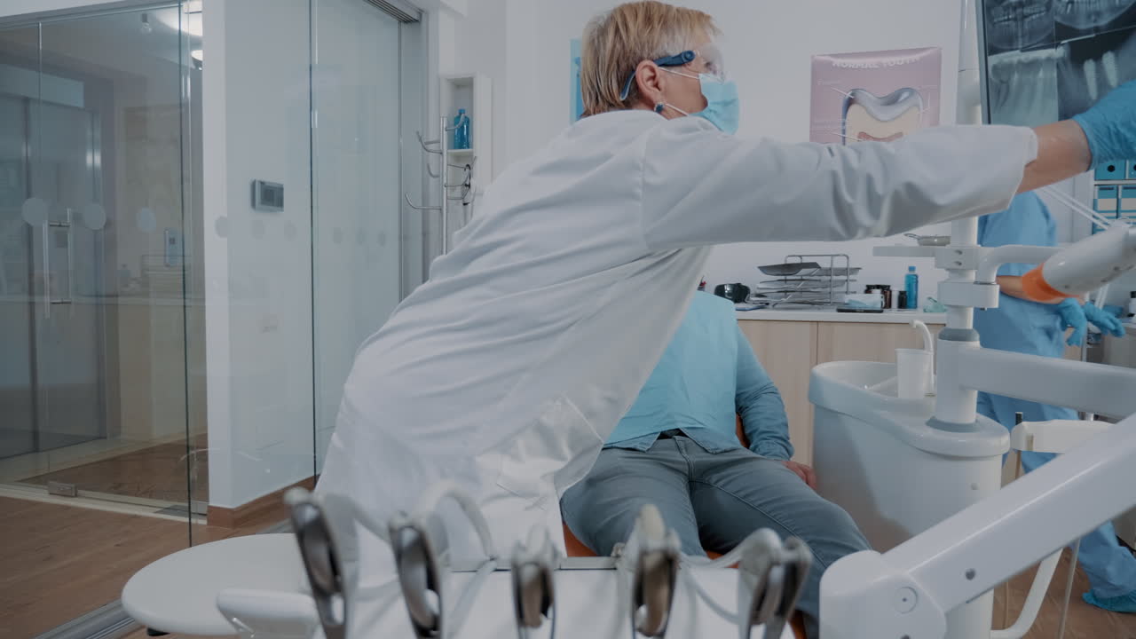 stomatologo che usa un monitor per mostrare alla persona la scansione a raggi x della dentatura dentale