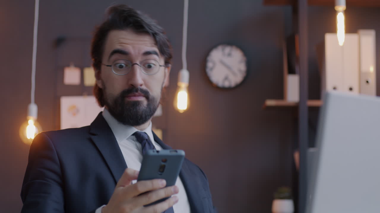 Businessman Checking Mobile Phone in Office