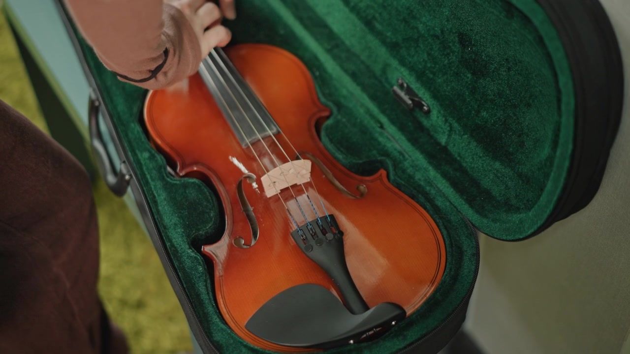 Open violin case with bow and velvet lining, hand reaching to lift polished instrument, student preparing for lesson in school setting, rosin on bow, tuning peg detail, gentle daylight highlighting