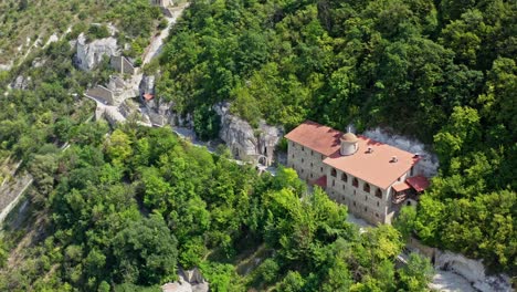 beautiful buildings in the mountains. stone architecture on the hill among green nature in summer. camera moving down.