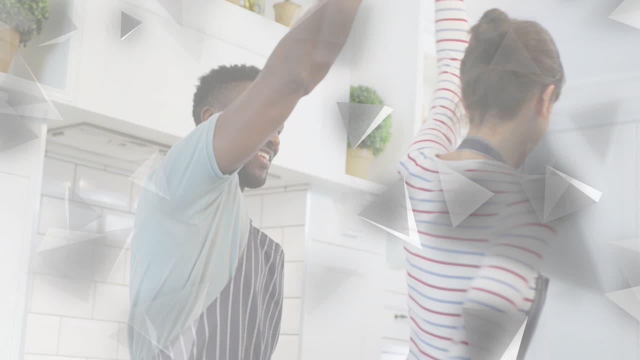 Couple dancing in kitchen, man raising woman's hand initiating romantic twirl with animating shapes